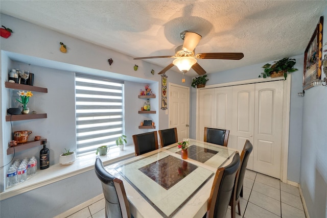 dining area with light tile patterned floors, baseboards, a textured ceiling, and a ceiling fan