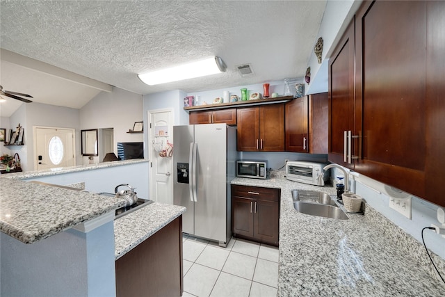 kitchen featuring light tile patterned floors, a ceiling fan, a sink, stainless steel appliances, and vaulted ceiling