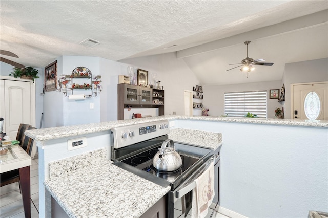 kitchen featuring visible vents, lofted ceiling with beams, electric stove, a textured ceiling, and a ceiling fan