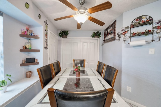 dining room with a ceiling fan, baseboards, and a textured ceiling