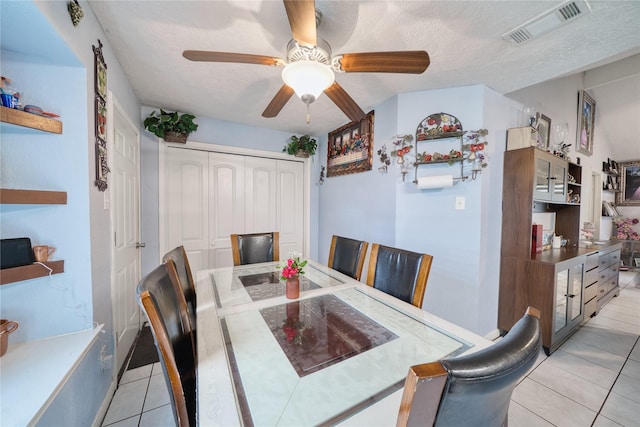 dining area with light tile patterned floors, visible vents, and a textured ceiling