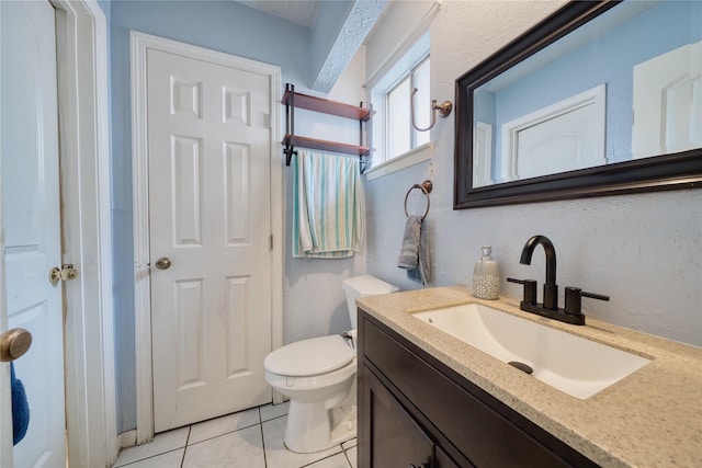 bathroom featuring toilet, vanity, and tile patterned flooring