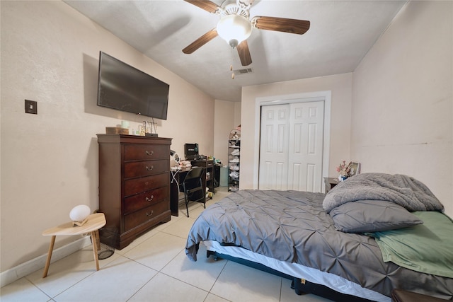 bedroom with visible vents, baseboards, light tile patterned flooring, a closet, and a ceiling fan