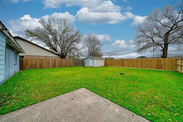 view of yard with an outdoor structure, a storage unit, a fenced backyard, and a patio area