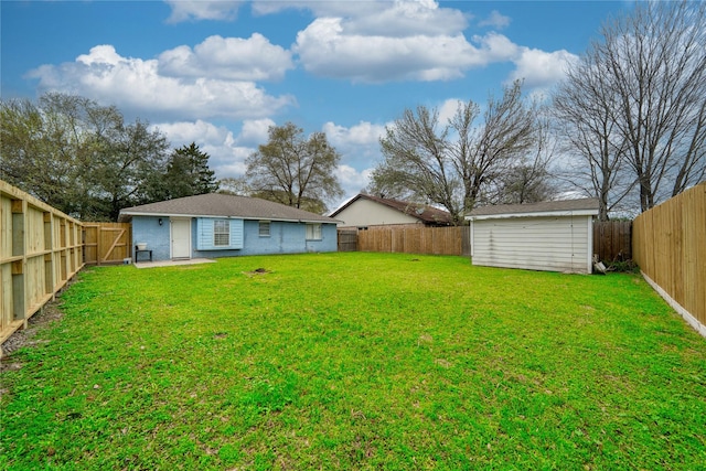 view of yard with an outdoor structure, a storage unit, and a fenced backyard