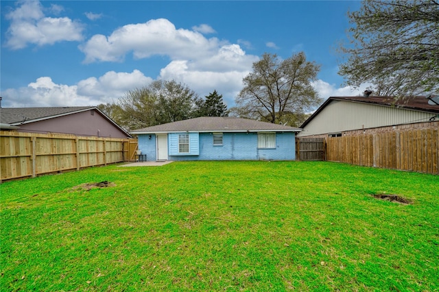 back of property featuring a patio area, a yard, a fenced backyard, and brick siding