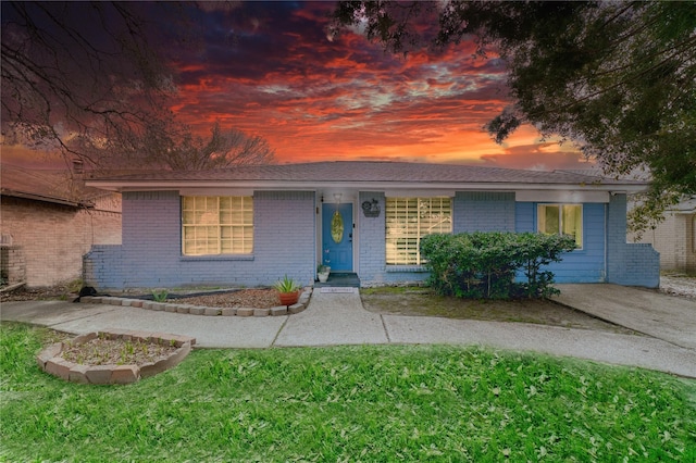 single story home with brick siding and a front yard