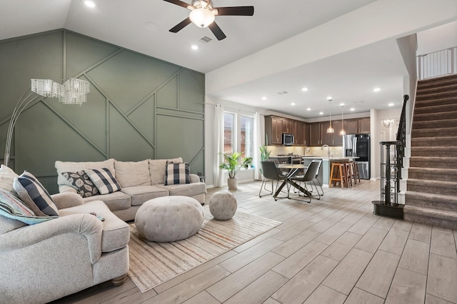 living area featuring recessed lighting, wood tiled floor, stairs, and vaulted ceiling