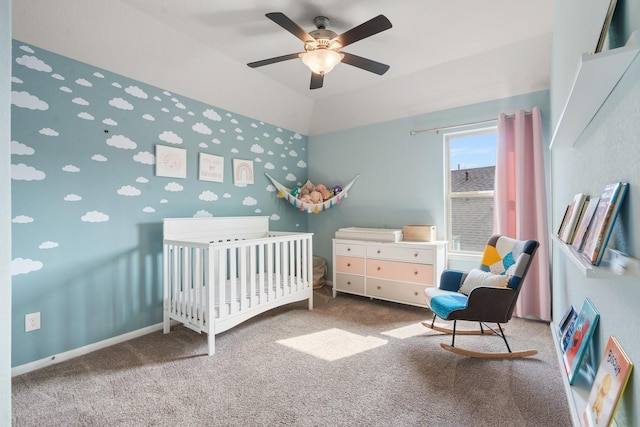 carpeted bedroom featuring baseboards, a nursery area, lofted ceiling, and a ceiling fan