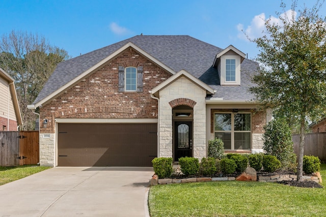 view of front of house featuring brick siding, roof with shingles, driveway, and fence