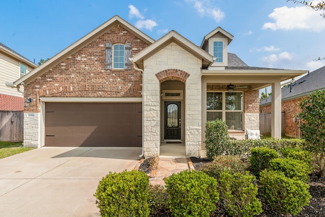 view of front of property with brick siding, stone siding, an attached garage, and concrete driveway