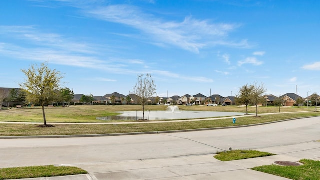 view of road with a residential view, curbs, a water view, and sidewalks