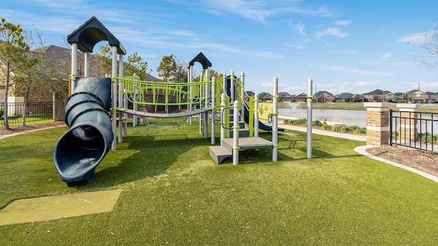 communal playground featuring a yard and fence