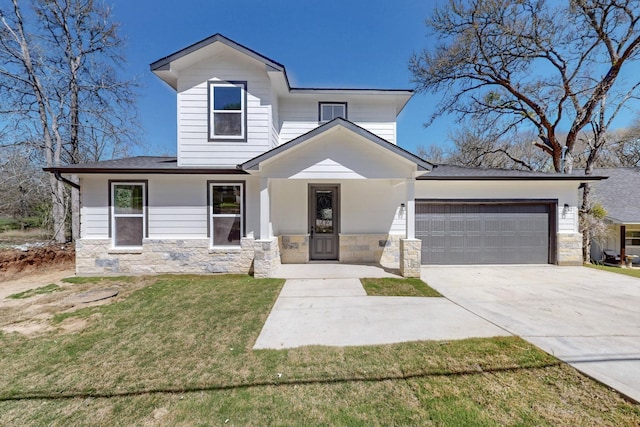 view of front of property featuring stone siding, an attached garage, concrete driveway, and a front yard