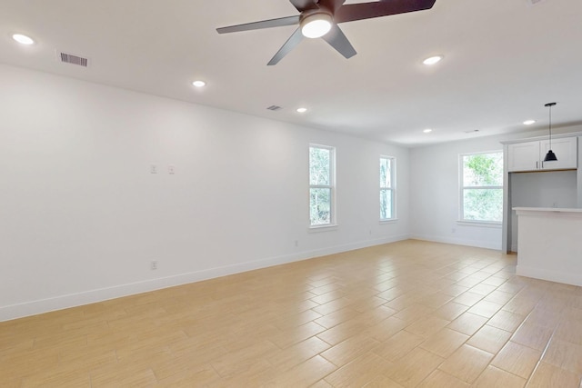 unfurnished living room featuring visible vents, a ceiling fan, recessed lighting, light wood finished floors, and baseboards