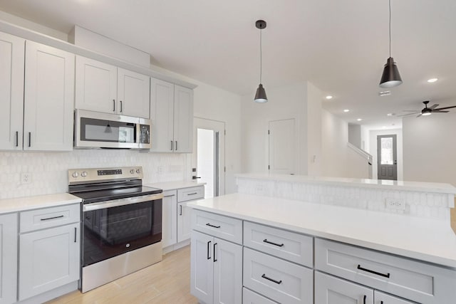 kitchen with decorative backsplash, light countertops, and appliances with stainless steel finishes