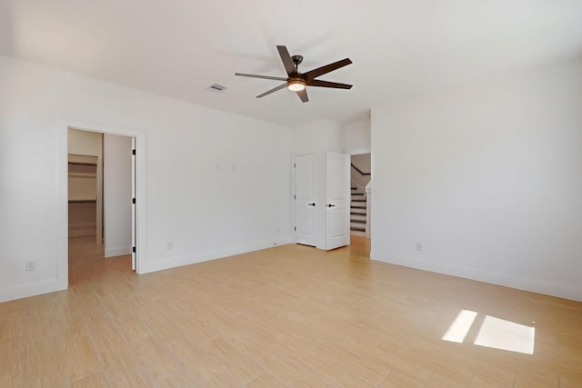 empty room featuring ceiling fan, visible vents, baseboards, and light wood-style flooring