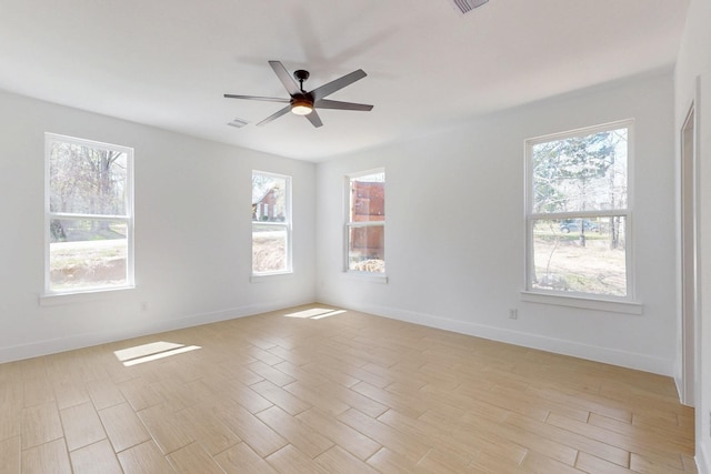 empty room featuring visible vents, ceiling fan, baseboards, and light wood-style floors