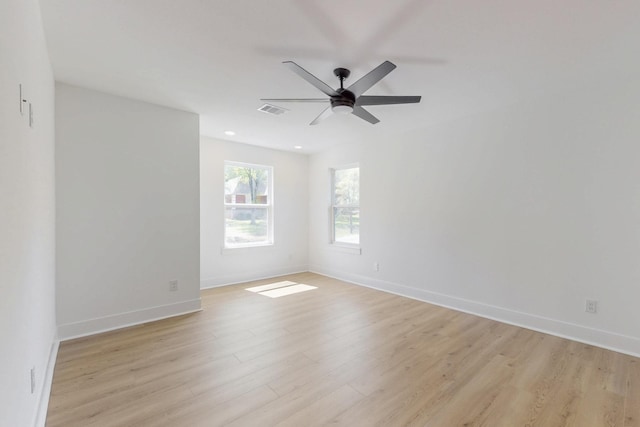 spare room featuring light wood-style flooring, baseboards, visible vents, and ceiling fan