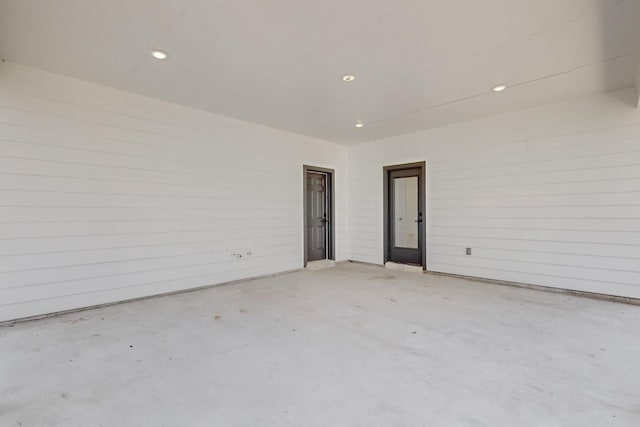 empty room with unfinished concrete flooring and recessed lighting