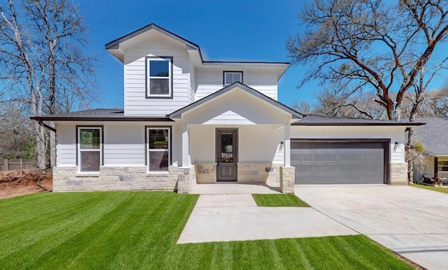 view of front of house with stone siding, concrete driveway, a front yard, and a garage