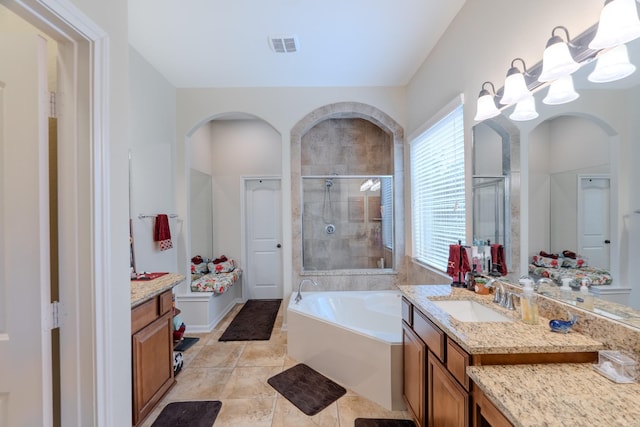 bathroom with vanity, a shower stall, a garden tub, and visible vents