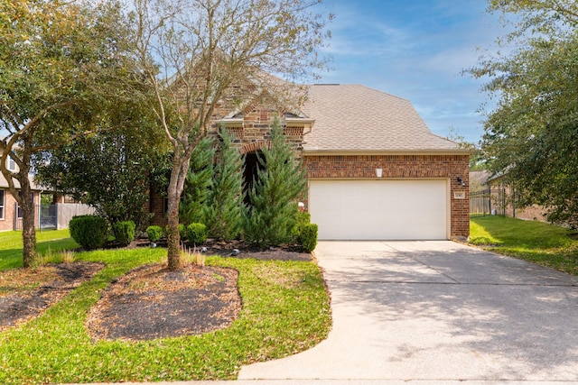 view of front of home with fence, driveway, an attached garage, a front lawn, and brick siding