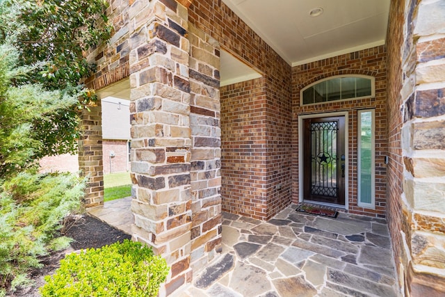 view of exterior entry featuring brick siding