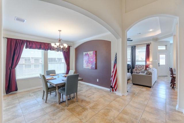 dining space featuring visible vents, a notable chandelier, arched walkways, crown molding, and baseboards