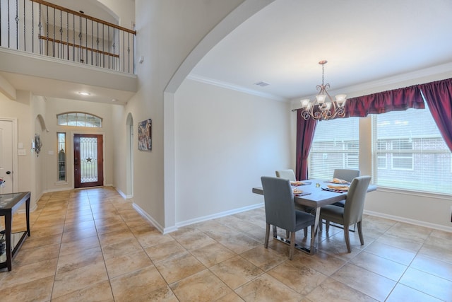 dining room with an inviting chandelier, baseboards, arched walkways, and ornamental molding