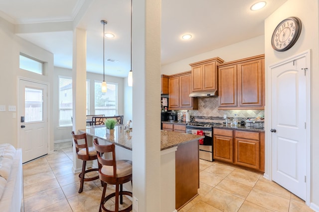 kitchen with tasteful backsplash, visible vents, under cabinet range hood, stainless steel range with gas stovetop, and dark stone counters