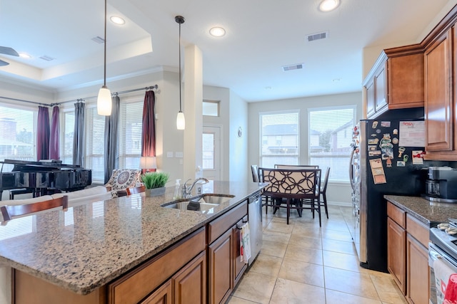 kitchen featuring brown cabinets, visible vents, stainless steel appliances, and a sink