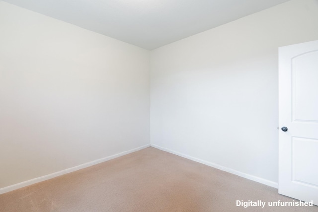 empty room with light colored carpet and baseboards