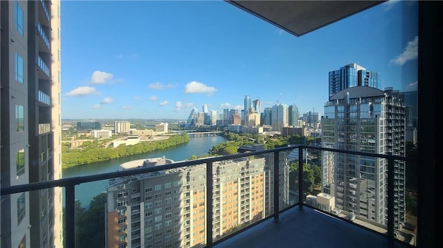 balcony featuring a water view and a city view