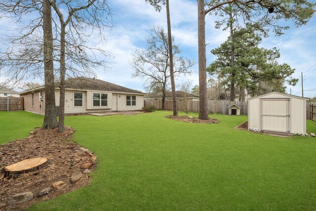 view of yard featuring an outbuilding, a fenced backyard, and a shed