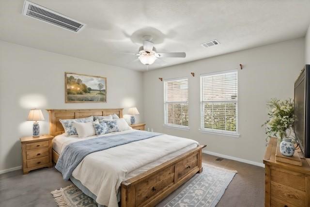 bedroom featuring visible vents, baseboards, ceiling fan, and carpet flooring