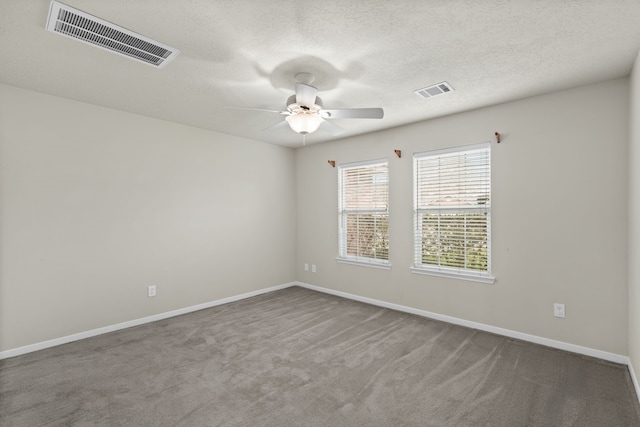 carpeted spare room with visible vents, baseboards, a textured ceiling, and ceiling fan