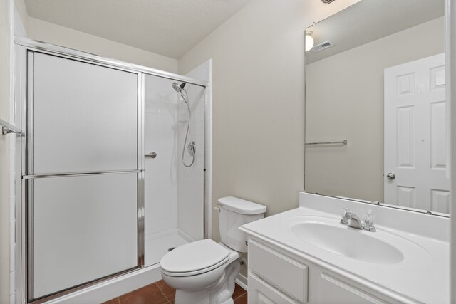 bathroom with tile patterned flooring, visible vents, a shower stall, toilet, and vanity