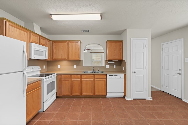 kitchen with visible vents, light countertops, arched walkways, white appliances, and a sink