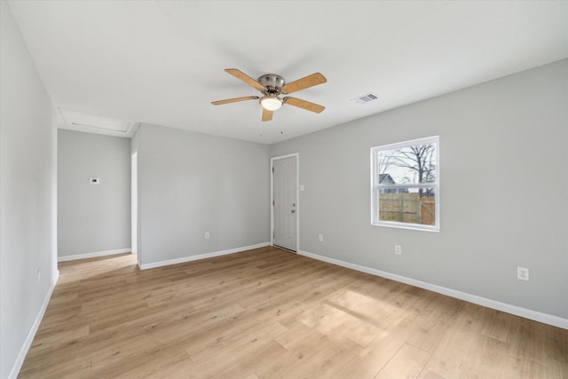 unfurnished room featuring baseboards, visible vents, light wood finished floors, attic access, and ceiling fan