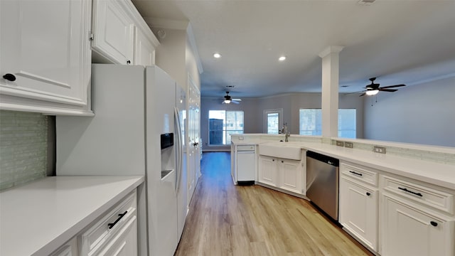 kitchen with dishwasher, white refrigerator with ice dispenser, white cabinetry, and a sink