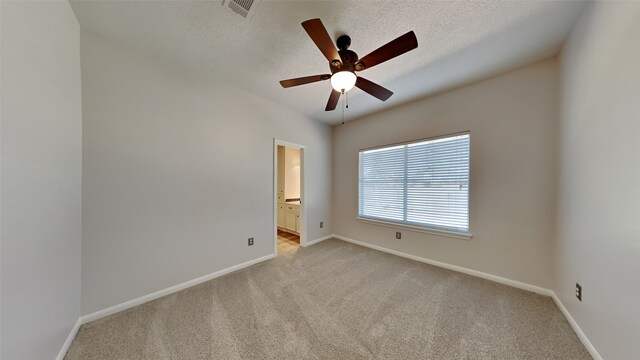 empty room with visible vents, baseboards, ceiling fan, a textured ceiling, and light colored carpet