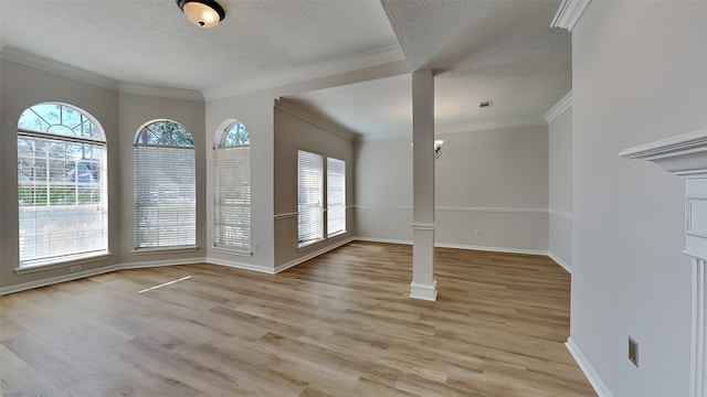 foyer entrance featuring plenty of natural light, a textured ceiling, light wood-style flooring, and ornamental molding