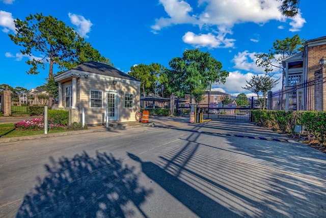 view of road featuring a gate, curbs, and a gated entry