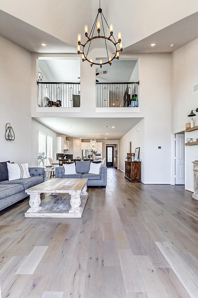 unfurnished living room with a high ceiling, wood finished floors, and a chandelier