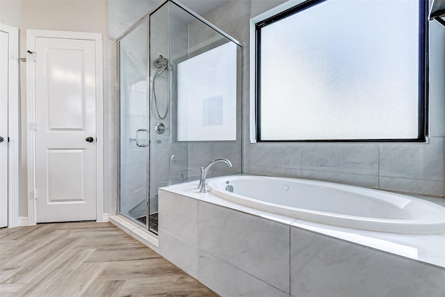 bathroom with a stall shower and a garden tub