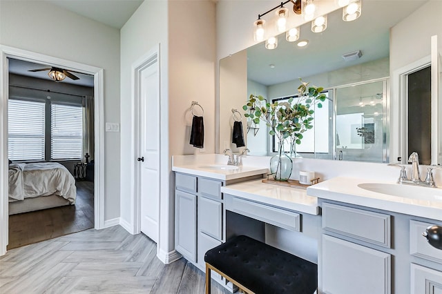 ensuite bathroom featuring a sink, visible vents, a stall shower, and double vanity