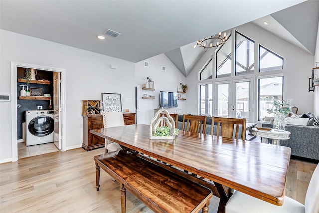 dining area with visible vents, light wood finished floors, washer / dryer, recessed lighting, and a chandelier