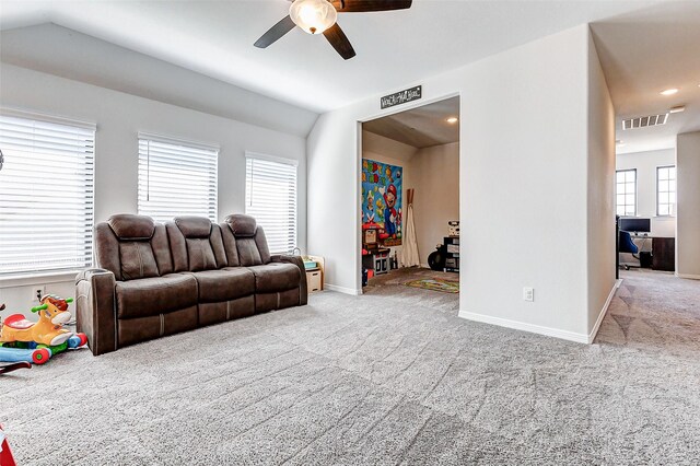 living area with vaulted ceiling, a healthy amount of sunlight, visible vents, and carpet floors