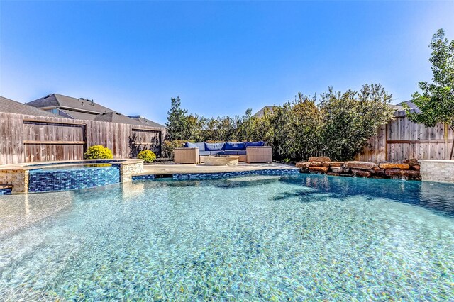 view of swimming pool featuring a patio area, a fenced backyard, outdoor lounge area, and a pool with connected hot tub